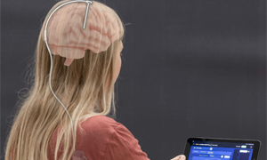 Frau sitzt vor Tablet und macht Neurofeedback