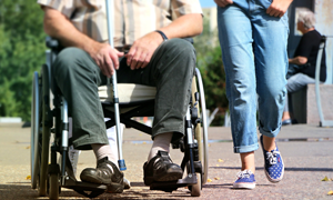 two people from the waste down. one in a wheel chair, one on foot